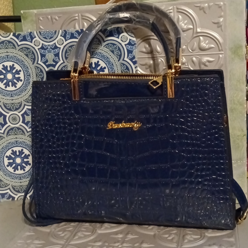 Crocodile patterned print navy blue handbag with gold hardware.